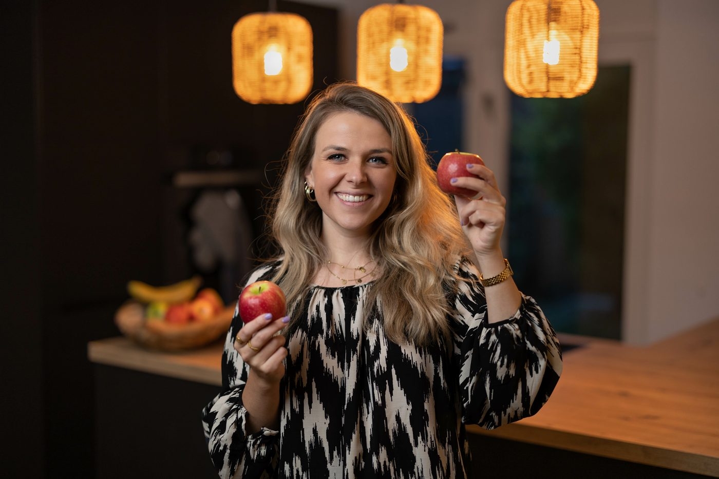 Marije met een appel in haar keuken
