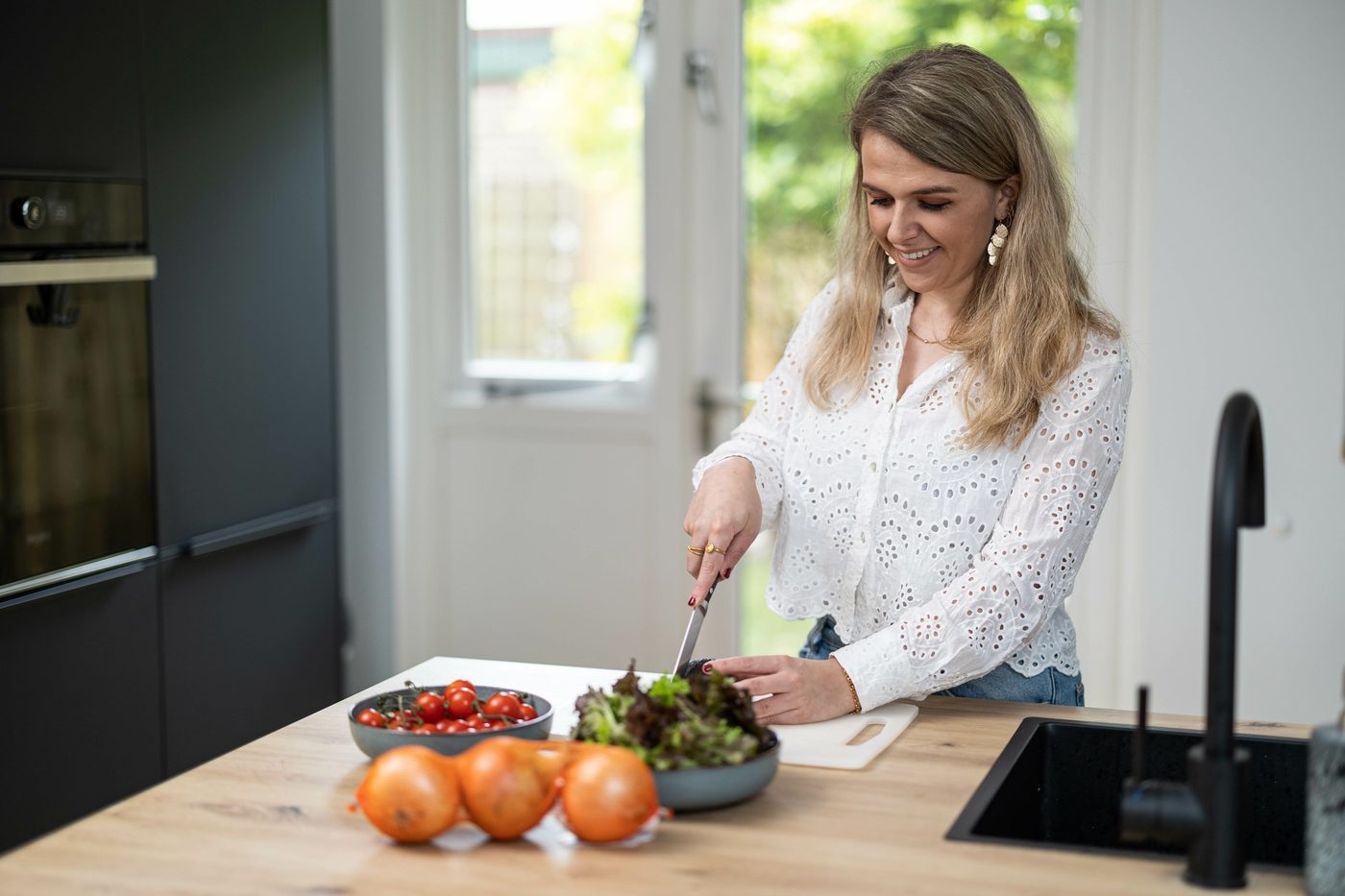 Marije maakt een salade in de keuken