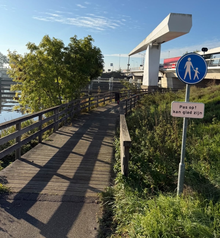 Houten vlonderpad bij de Gouderakse brug met een bord 