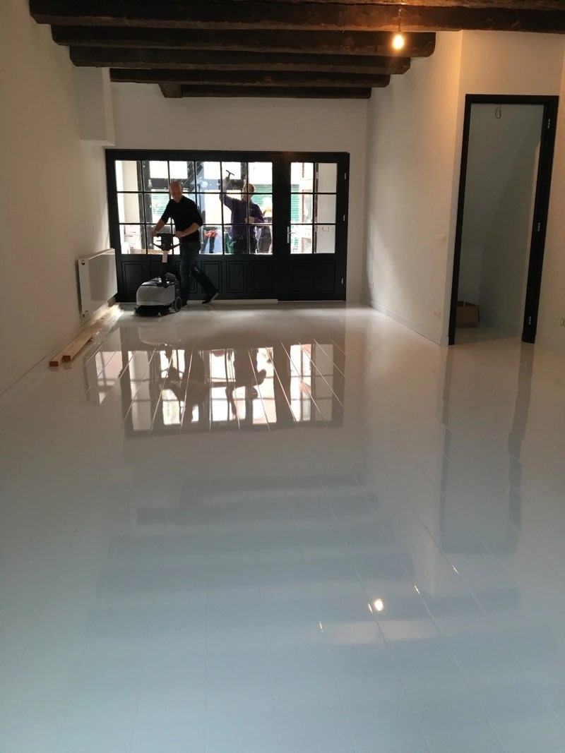 Medewerkers van De Schoonmaak reinigen de vloer en ramen bij een oplevering