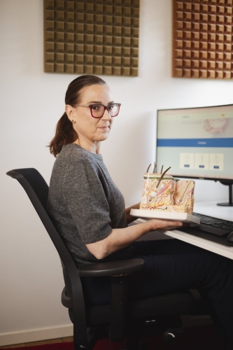 Dr. Annemie Galimont aan haar bureau met een huidmodel