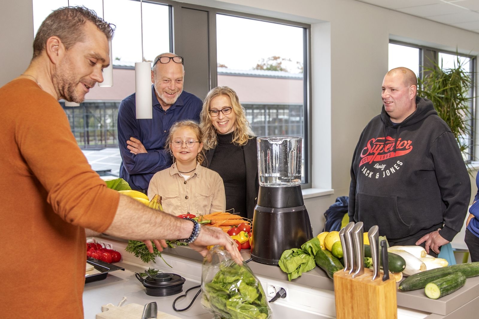 Jong en oud koken samen met verse groenten