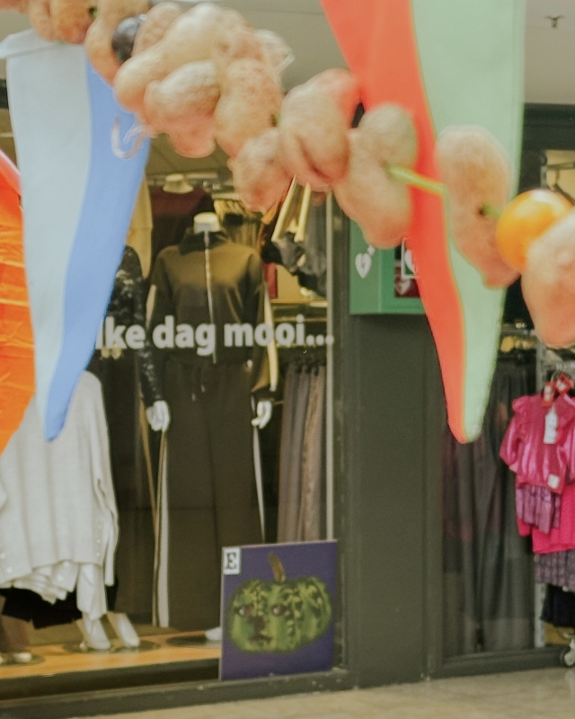 Pompoen in de etalage, slingers en herfstversiering in het winkelcentrum
