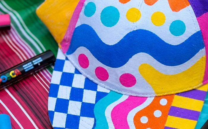 Kinderen ontwerpen hun eigen petje met Posca-stiften. Golven, namen, hartjes