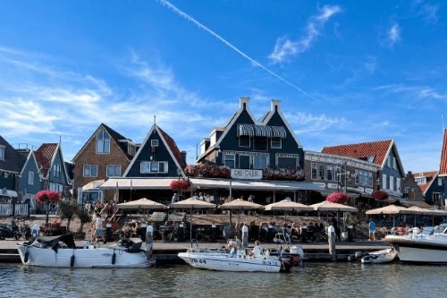Gevel en terras van café-restaurant De Dijk aan de haven van Volendam, gezien vanaf het water
