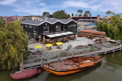 Grand Café de Botterwerf met terras en botters aan de steiger in Volendam, van bovenaf gezien