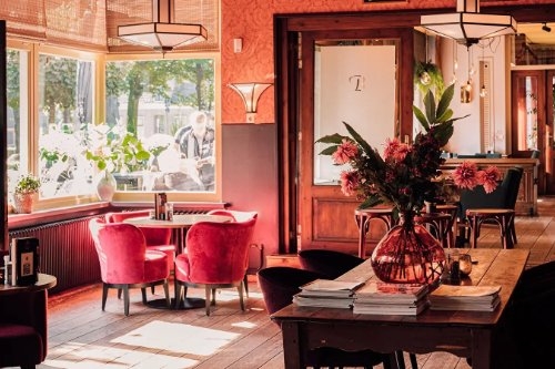 Grand Café de Brink in Dwingeloo Interieur van Grand Café de Brink met rode stoelen bij het raam in Dwingeloo
