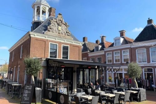 Terras en serre voor Grand Café de Waegh in de oude waag met klokkentorentje in Dokkum