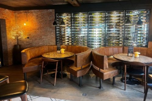 Het Wapen van Zeeland in Renesse Leren loungebanken voor een verlichte wijnwand in eetcafé Het Wapen van Zeeland in Renesse