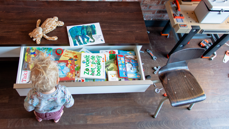 Boekenlade op kinderhoogte Interieurontwerp — opbergruimte voor kinderen — open lade met boeken op kinderhoogte
