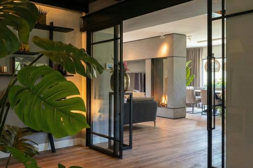 Interieurontwerp vrijstaande villa Rhoon — woonkamer met stalen pui en mountain oak vloer Interieurontwerp vrijstaande villa Rhoon — woonkamer met stalen pui en mountain oak vloer