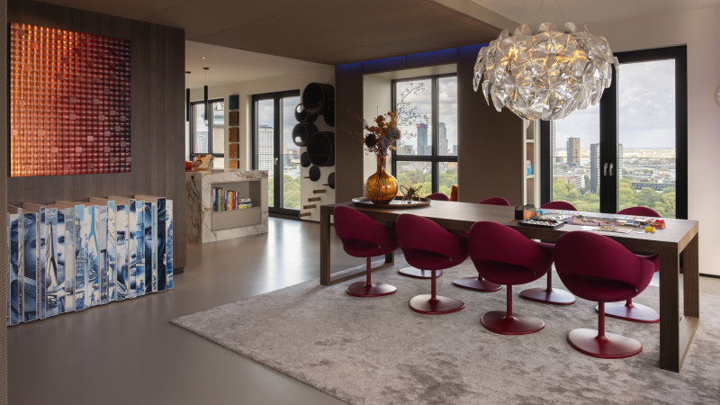 Eethoek met rode stoelen en uitzicht over Rotterdam Penthouse-interieur — eethoek — donkere tafel met rode stoelen en uitzicht over Rotterdam